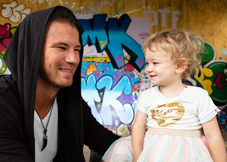Vater mit Tochter in einem Lost Place. Im Hintergrund erkennt man Graffitis.