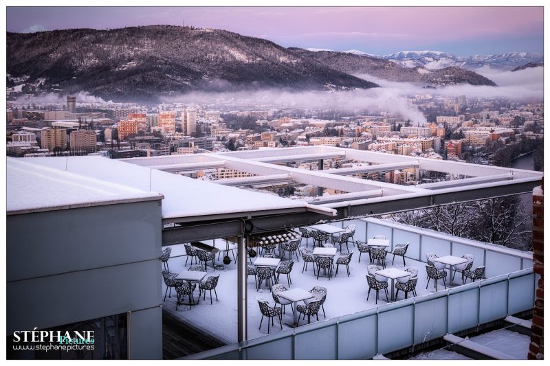 Blick vom Schloßberg über die mit Schnee bedeckten Dächer der Stadt